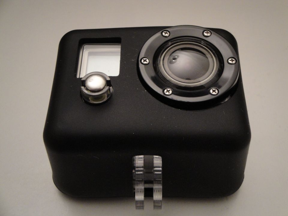 Black action camera in a clear plastic housing, front view, showing lens and small screen