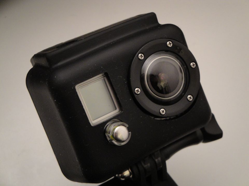 Black action camera with a lens and a small screen