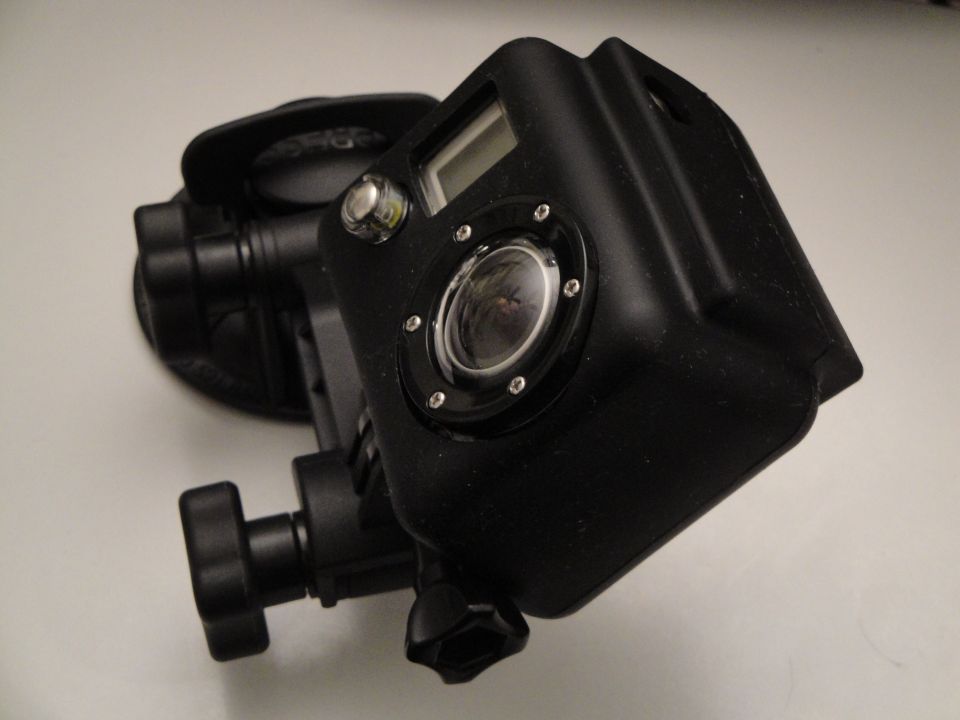 Black action camera in a protective housing with a lens and a small screen
