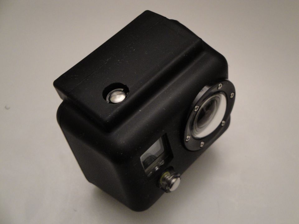 Black action camera in a matte protective housing on a gray background