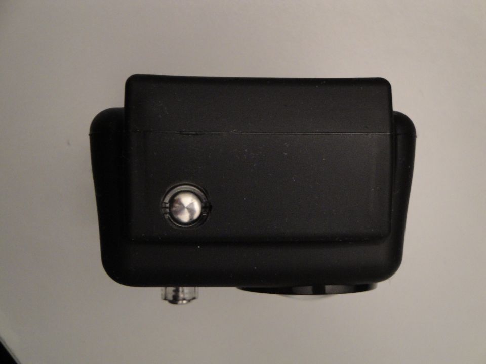 Black camera with a silver button on top and a lens on the bottom
