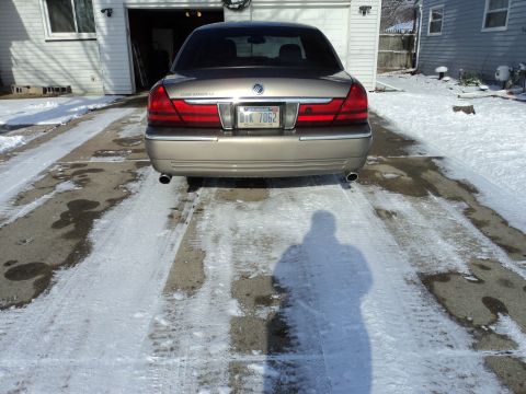 2004 Mercury Grand Marquis - Rear view of a gold 2004 Mercury Grand Marquis LS parked in a snowy driveway.