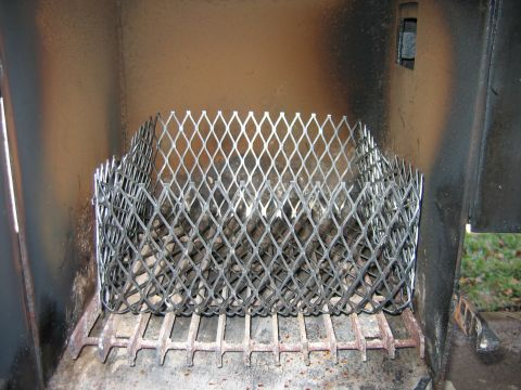 1992 Ford Bronco - Interior view of a smoker, showing a metal grate and a diamond mesh cage, likely for holding wood chips or coals.