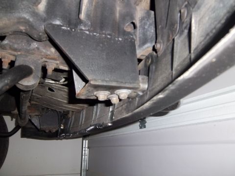 1995 Ford Bronco - Underside view of vehicle chassis components, showing structural brackets and fasteners.