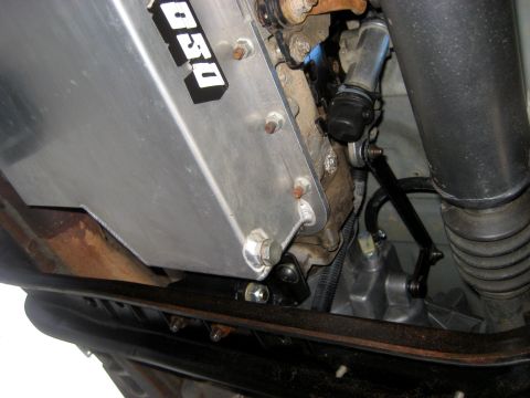 1996 Ford Bronco - Close-up view of a vehicle's underbody, showing a skid plate and parts of the drivetrain.