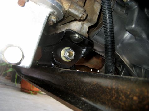 1996 Ford Bronco - Close-up view of a vehicle's transmission mount bracket and associated hardware.