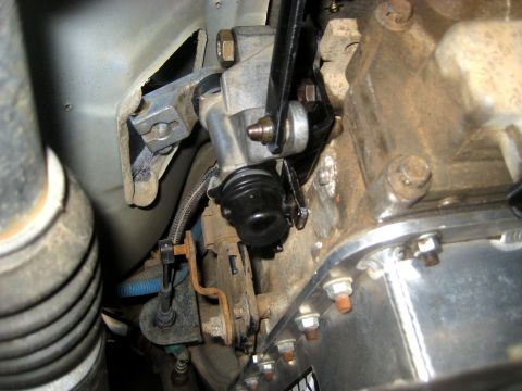1996 Ford Bronco - Close-up view of the clutch slave cylinder and transmission housing, showing mechanical components and mounting hardware.