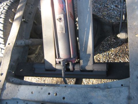1972 Ford F-250 - The underside of a truck chassis shows a hydraulic cylinder and part of a tire. The SUPERMOTORS.NET watermark is visible.