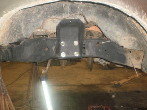 1995 Ford Bronco - Close-up view of vehicle frame and suspension parts, with a newly installed bracket.