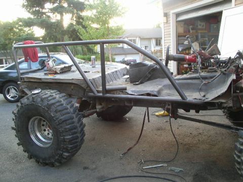1979 Ford Bronco - A heavily modified vehicle, likely a custom build, is seen in a driveway with a roll cage and large off-road tires.