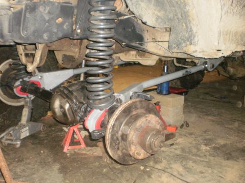 1995 Ford Bronco - Close-up view of the front axle and suspension system, likely undergoing modification or repair.