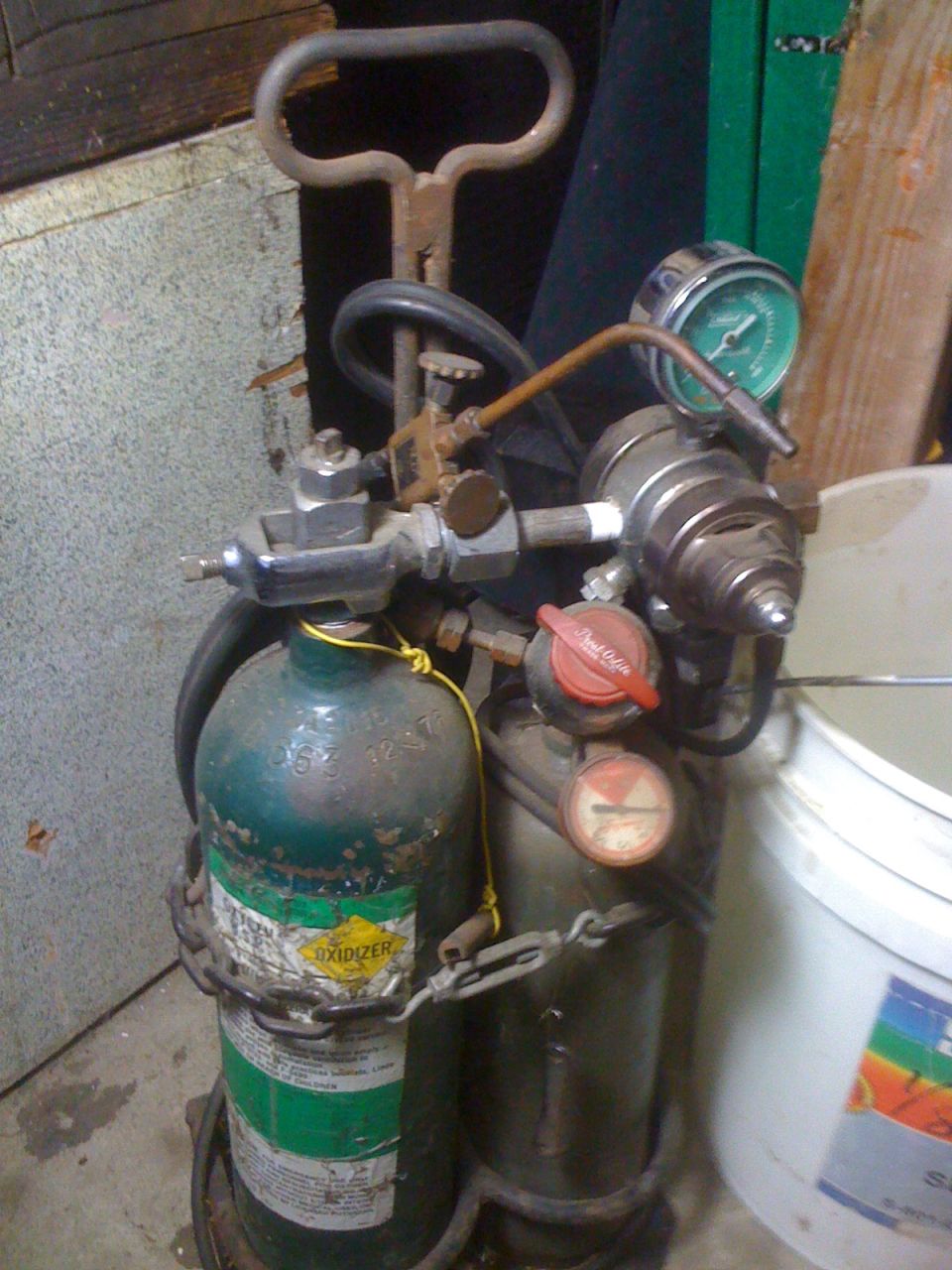 oxy-acetylene welding tanks with gauges and hoses, chained together
