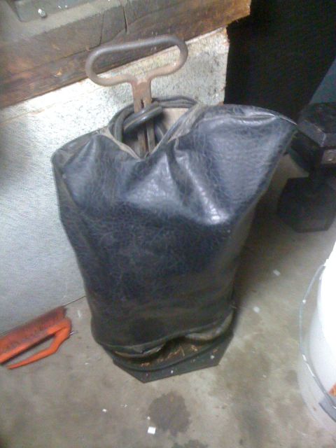 1968 Ford Mustang - A black leather bag with a metal handle and an orange tool on the floor.