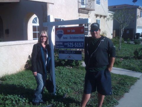 1968 Ford Mustang - Two people pose next to a real estate sign outside a house that has been sold.