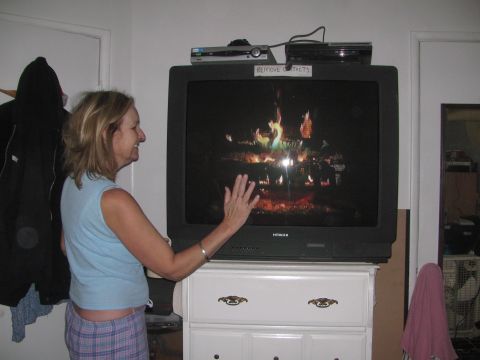 1968 Ford Mustang - A woman watches a simulated fireplace on a television set in a room with a dresser and closet.