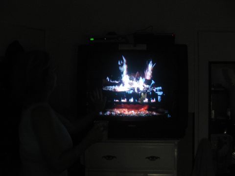 1968 Ford Mustang - A person watches a television displaying a simulated fireplace in a dimly lit room.