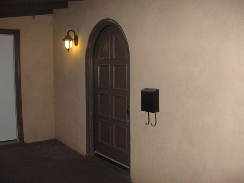 1968 Ford Mustang - Exterior view of an arched doorway a dark brown door, a black mailbox, and a vintage-style lantern.