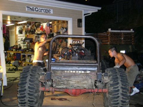 1979 Ford Bronco - Two men are working on a custom off-road vehicle in a garage setting.