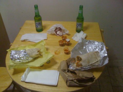 1968 Ford Mustang - Two burritos and two bottles of Rolling Rock beer are on a wooden table with small sauce containers.