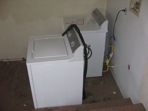 1968 Ford Mustang - Two washing machines are visible in a room with a dirty floor and unfinished walls.