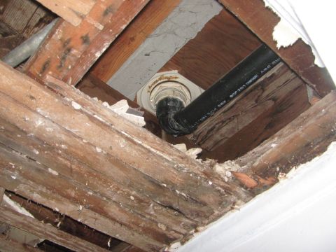 1968 Ford Mustang - Exposed plumbing pipes and damaged ceiling joists are visible in this close-up view.