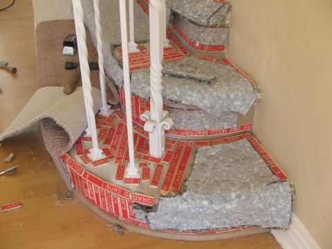 1968 Ford Mustang - A staircase is partially dismantled, revealing the underlayment and red grip tape as part of a renovation project.