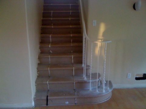 1968 Ford Mustang - A view of an interior staircase with wooden steps and a white railing, likely undergoing renovation.