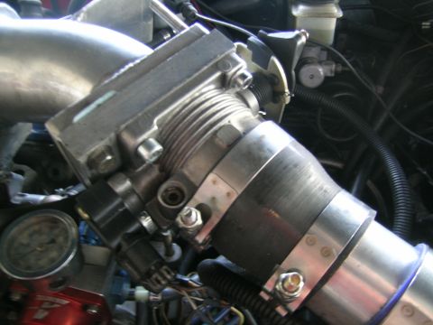 1995 Ford Probe - Engine throttle body and intake piping with a gauge visible in the background.