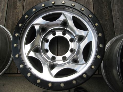 1986 Ford Bronco - A single chrome and black beadlock wheel is shown, with other wheels partially visible in the background.