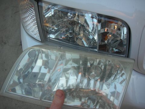 2004 Ford Crown Victoria - Comparing a clear 2003 Ford Crown Victoria headlight with one installed on a white vehicle.