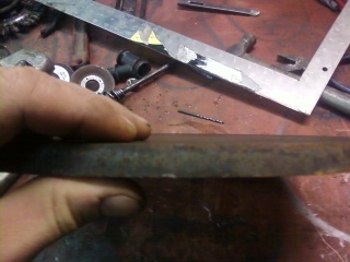 1995 Ford Bronco - A rusty metal part is held in a hand, with a Supermotors.net logo in the background.