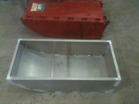 1986 Chevrolet Blazer - An aluminum fuel tank sits in front of a red object, possibly another tank, on a concrete floor.