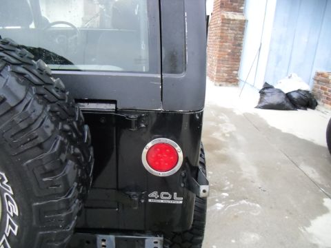 1992 Jeep Wrangler - Rear view of a black Jeep Wrangler showing the spare tire and a '4.0L HIGH OUTPUT' badge.