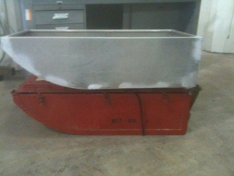 1986 Chevrolet Blazer - A metal tank is placed on top of a red container, with some text visible on the container's side.