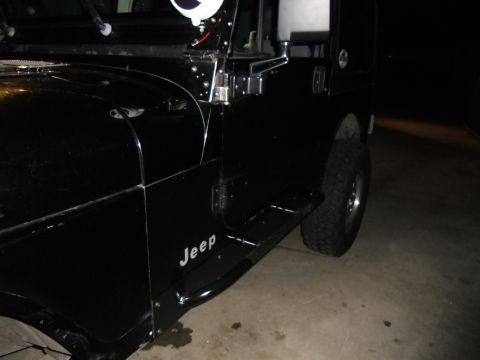 1992 Jeep Wrangler - A black 1992 Jeep Wrangler is shown from the side, with its door, fender, and running board visible.
