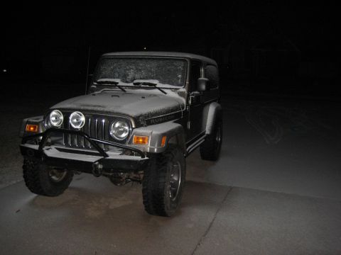 2005 Jeep Wrangler - A Jeep Wrangler Rubicon is parked on a paved surface at night, covered in a light dusting of snow.