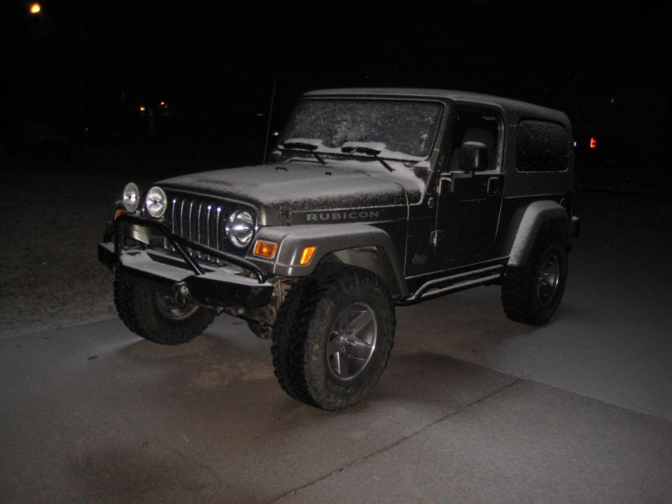 Charcoal Jeep Wrangler Unlimited Rubicon with snow dusting at night