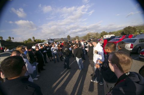 2006 Cadillac STS - A gathering of people surrounds several cars, including a silver 2006 Cadillac STS, in an outdoor parking area.