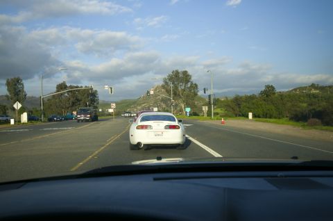 2006 Cadillac STS - A white Toyota Supra is seen driving on a highway with other vehicles.