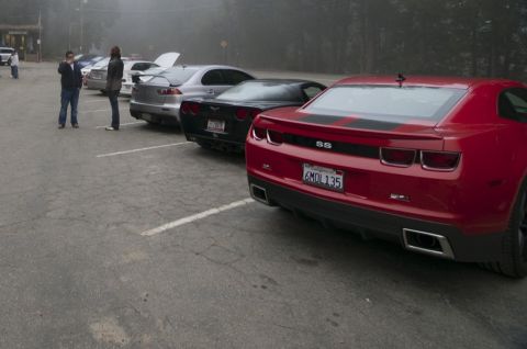 2006 Cadillac STS - Several cars are parked in a lot, including a red Chevrolet Camaro SS.
