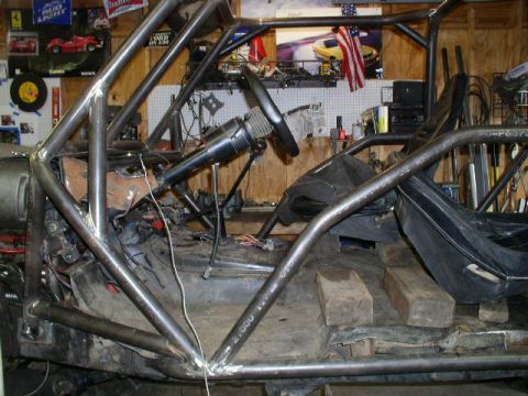 1979 Ford Bronco - The interior of a vehicle is visible, a custom-built roll cage and exposed components.