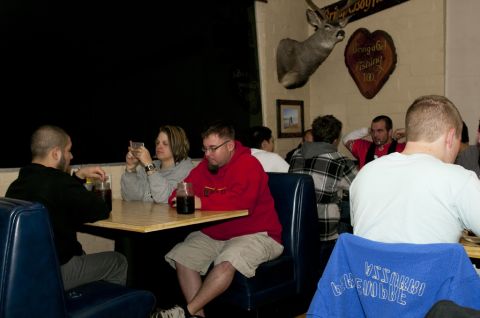 2006 Cadillac STS - A group of people are seated at tables in a dimly lit restaurant, with a mounted deer head visible on the wall.