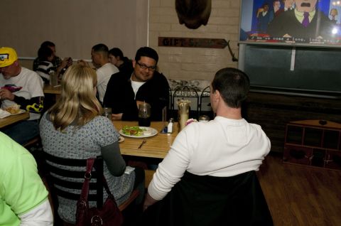 2006 Cadillac STS - Diners gathered at tables inside a restaurant, with a television displaying a cartoon.