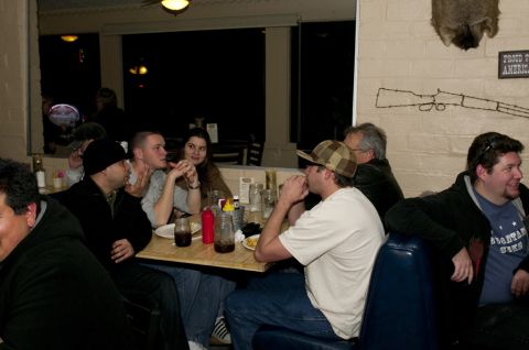 2006 Cadillac STS - A group of people are seated at tables inside a restaurant, with various decorations on the wall.