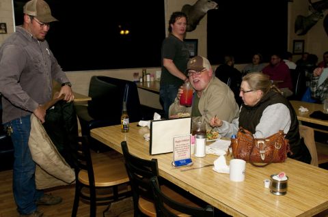2006 Cadillac STS - People gather at tables inside a dimly lit restaurant with mounted deer heads on the wall.