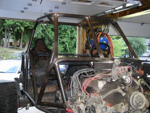 1979 Ford Bronco - This custom-built buggy features a prominent roll cage and an exposed engine, seen here in a garage setting.