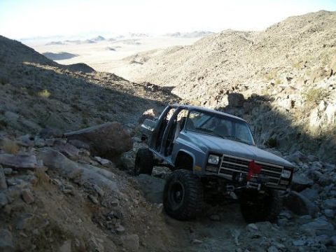 1990 Chevrolet Suburban - This 1990 Chevrolet Suburban navigates a challenging rocky terrain in a desert landscape.