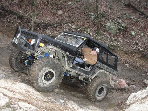 1967 Ford Mustang - This modified off-road vehicle navigates a challenging rocky terrain, its suspension and tire grip.