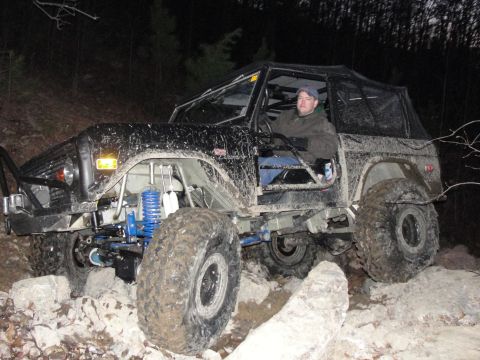 1967 Ford Mustang - A heavily modified off-road SUV navigates a rocky terrain in the dark.