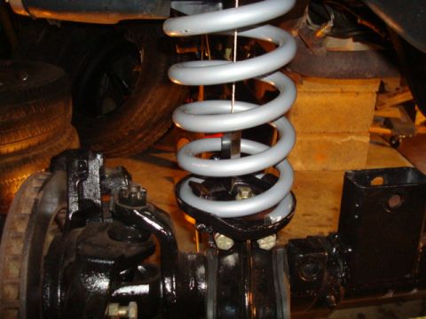 1995 Ford Bronco - Detail of a vehicle's suspension system, focusing on the coil spring and axle assembly.